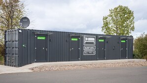Un albergue portátil con cuatro habitaciones, cada una identificada con 'ROATEL', y un cartel que dice 'SLEEP WELL' señalando una cama.