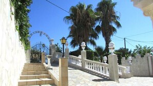 A stone staircase leading to a gated entrance with a white railing and decorative balusters. - Superior Duplex Apartment for 8 people (Rhodes)