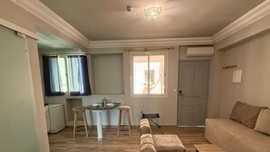 A compact living space with a kitchenette, a dining area, and a seating area with a sofa and a table. - Hamilton Suites & Appart (Casablanca)