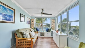 A cozy room with a wooden bench, a cushioned sofa, and a window seat overlooking a scenic view.