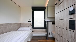 A modern bedroom with a bed, a small desk, and a wardrobe. - Roatel Gau Bickelheim A61 (Gau-Bickelheim)