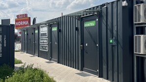 A row of modular hotel units with doors labeled "ROATEL" and "SLEEP WELL." - Roatel Magdeburg A2 (Magdeburg)