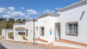 A white building with a tiled roof, a small porch, and a street lamp. - 1040  Casa Brisa Azul (Nerja)