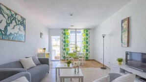 A modern living room with a grey sofa, a white coffee table, and a flat-screen TV. - 1040  Casa Brisa Azul (Nerja)