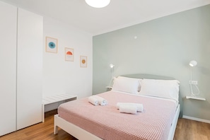 A neatly arranged bedroom with a bed, bedside lamps, and wall art. - Apartment 'Dal Pernè' with Mountain View, Wi-Fi and Air Conditioning (Volastra)