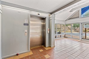 An elevator with a "No Smoking" sign, a fire alarm, and a "No Smoking in Elevator" sign. - Kingston Laurel Court 311- 2BR/2BA- Outdoor Pool (Myrtle Beach)