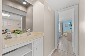 A bathroom with a sink, mirror, and decorative items. - Oceanfront 3BR/2BA- Pelican's Landing 404- Pool (Myrtle Beach)