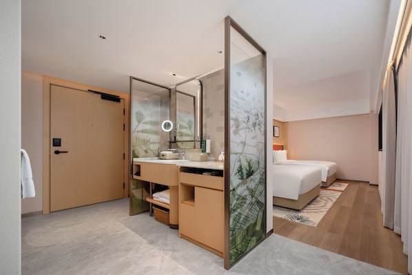 Une chambre d’hôtel moderne avec une porte en bois, une coiffeuse avec un miroir, un lit et une grande fenêtre.