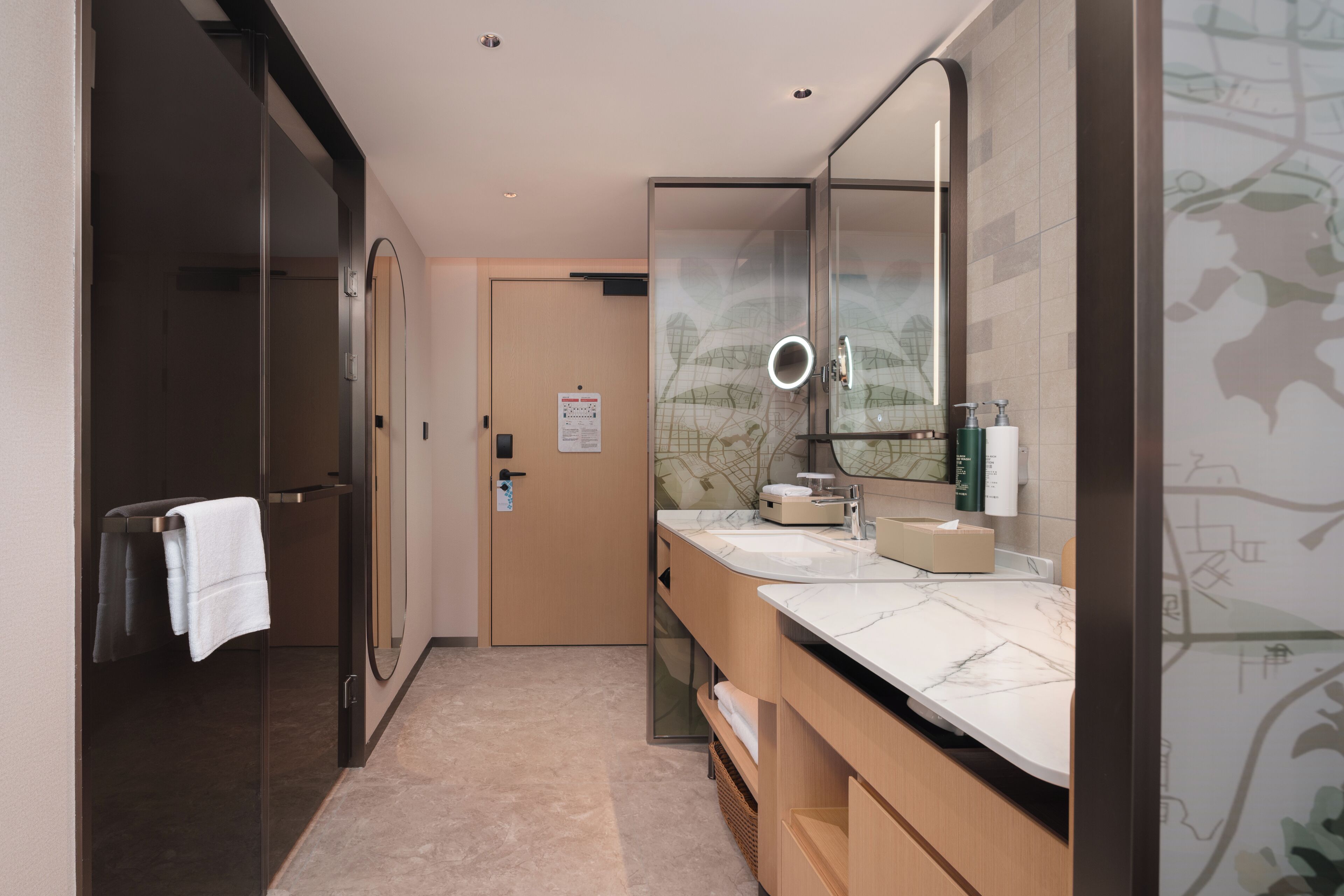 A modern bathroom with a glass shower, a large mirror, and a marble countertop.