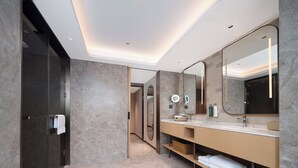 A modern bathroom with a large mirror, a shower, and a vanity with a towel rack. - Hilton Garden Inn Shenzhen Luohu Port (Shenzhen)