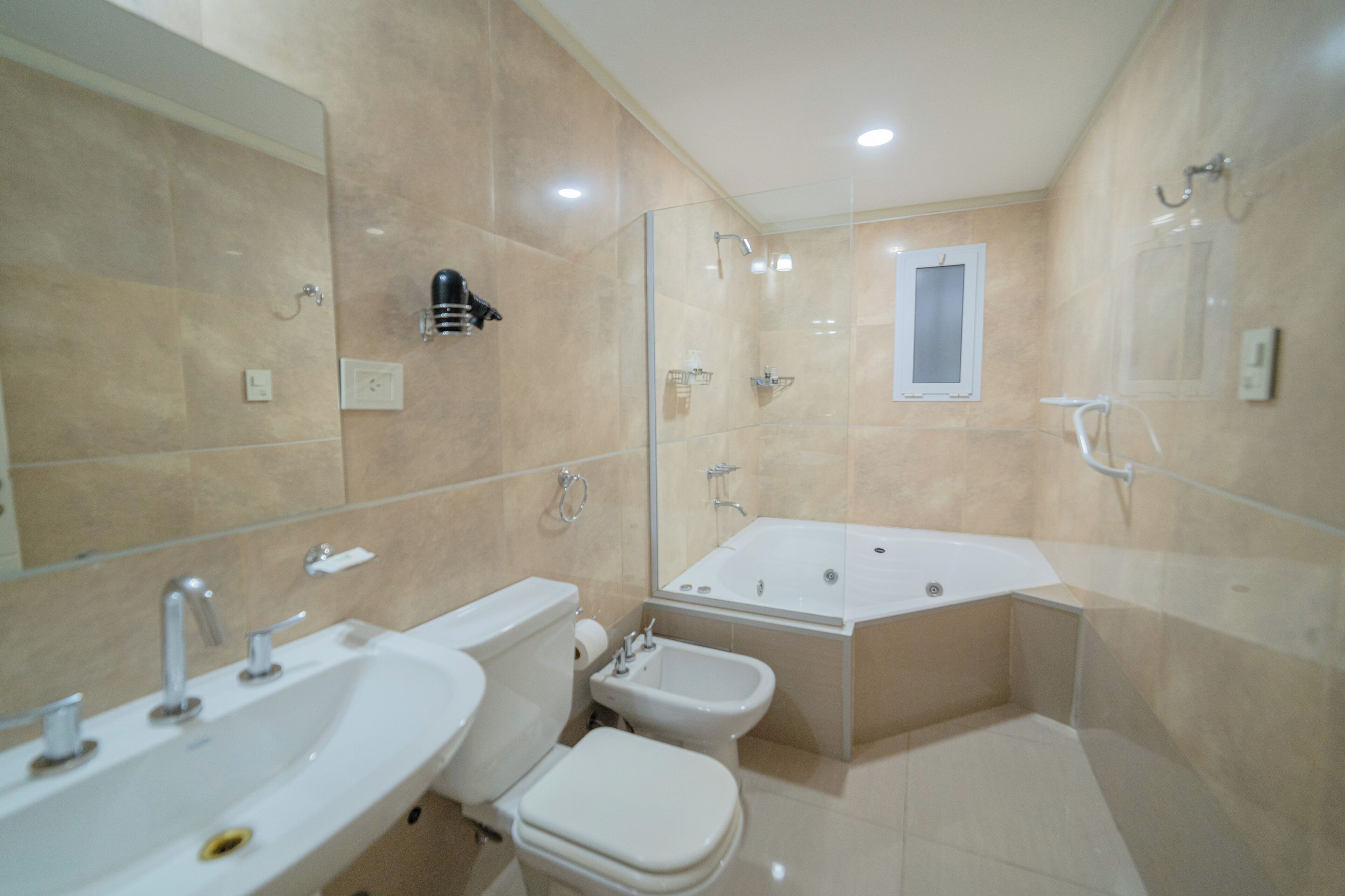 Un baño con bañera, bidé, inodoro y lavabo.