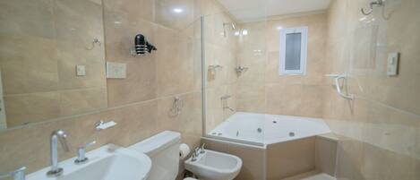A bathroom with a bathtub, a bidet, a toilet, and a sink.