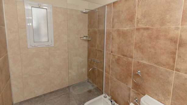 Une salle de bain avec une douche, des toilettes et un lavabo.