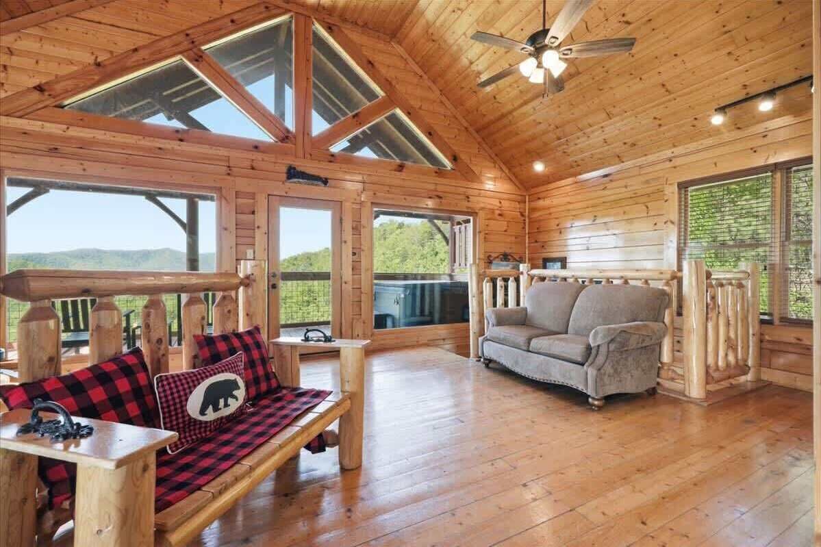 Et interiør af en træhytte med en sofa, en sofaarrangement og et spisebord.