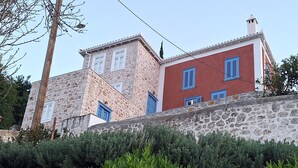 A stone building with blue shutters and a red facade.