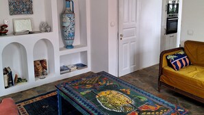 A living room with a patterned coffee table, a sofa, and a white door.