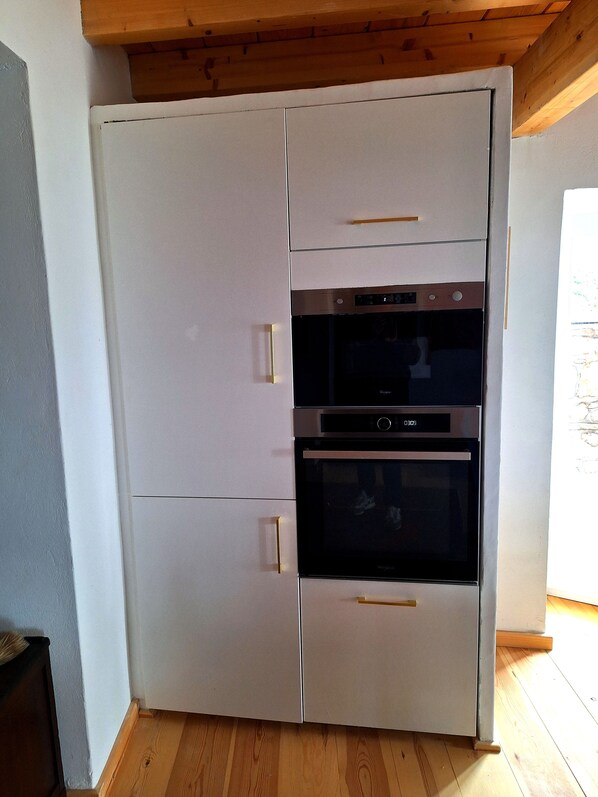 A white built-in kitchen with a double oven and a microwave. - Villa Helios - House for 9 people on Hydra (Kiafa). Spectacular view. (Idra)