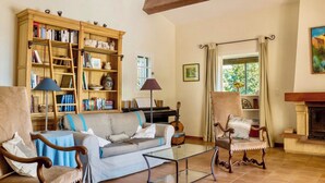 A living room with a sofa, chairs, a piano, a bookshelf, and a fireplace. - CASA-Stella Maris villa avec vue sur la mer (Cavalaire-sur-Mer)