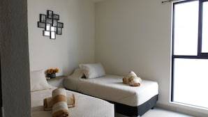 A modern bedroom with two beds, a large window, and a wall-mounted picture frame. - Furnished Apartment in Altea Condominiums, Puerto Vallarta, Jalisco. (Puerto Vallarta)