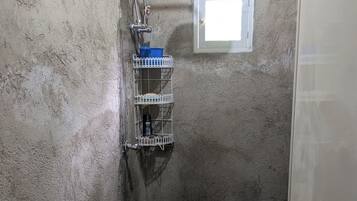 Een douche, handdoeken, zeep, toiletpapier