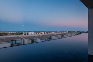 A modern hotel with a rooftop pool and a view of the sea. - Cora Sunset: Brand New Oceanview 3BR Near Golf, Pool & Swimmable/Surfable Beach (San José del Cabo)