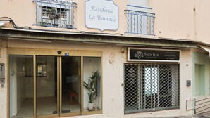 Ein Gebäude mit einem Schild, auf dem "Résidence La Ramade" und ein weiteres Schild für "Sabrina Conciérerie" steht.