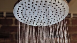 Un cabezal de ducha con agua corriendo.