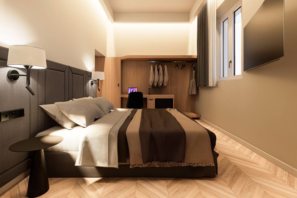 A modern hotel room with a bed, bedside table, lamp, TV, and a wooden wardrobe.