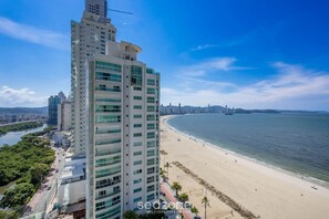 A high-rise hotel with a view of a beach and a river. - Apt With 2 Suites Beachfront in BC Eqc0801 (Balneário Camboriú)