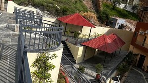 Terraza al aire libre de varios niveles con escaleras, barandillas y plantas en macetas.