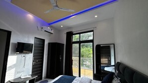 Un dormitorio moderno con cama, ventilador de techo y vistas al exterior.