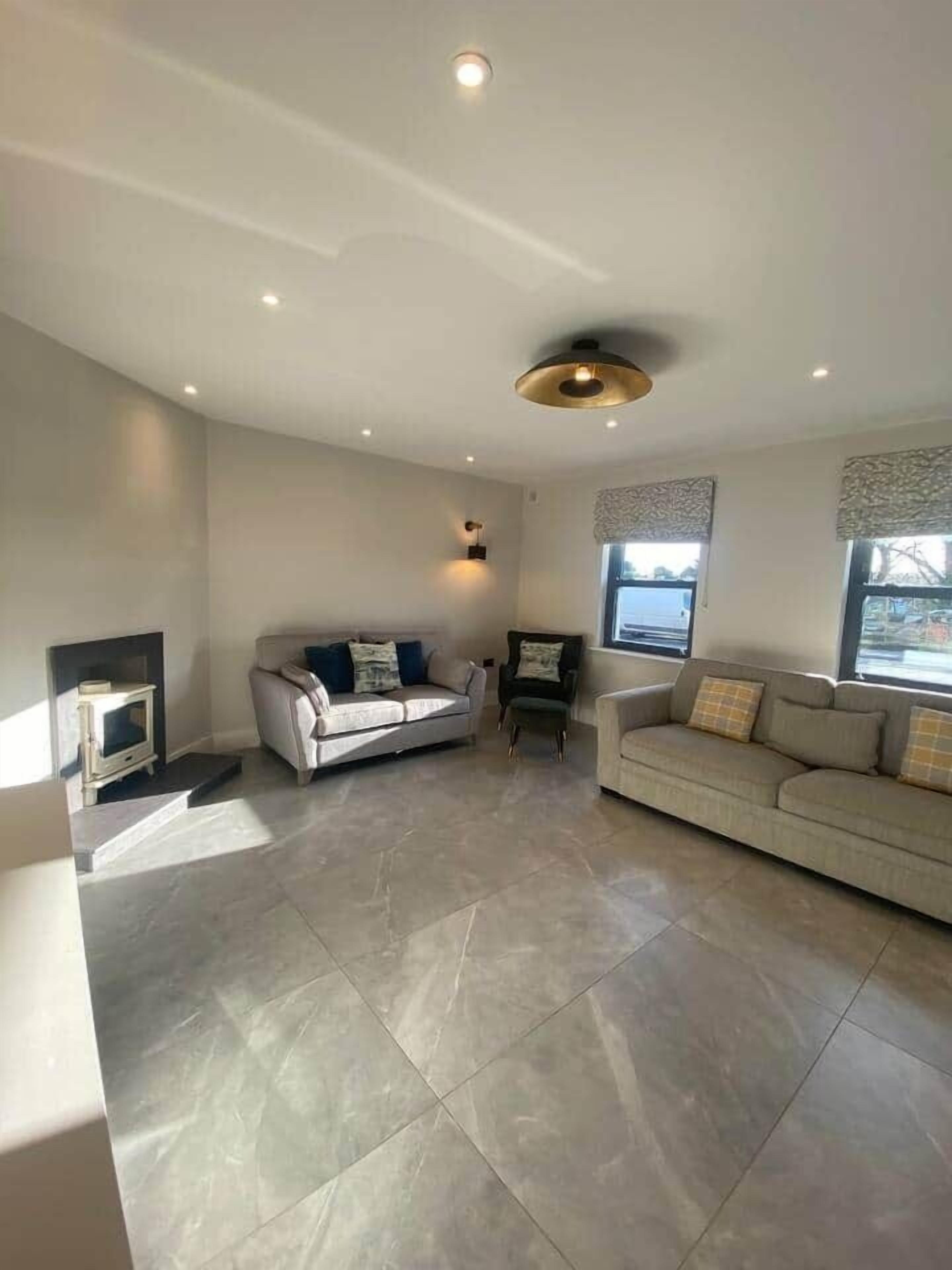 A spacious living room with a fireplace, two sofas, and a television.