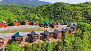 A lodge with multiple cabins, surrounded by forested hills. - NEW! Luxury Cabin w/Hot Tub & Stunning Mntn Views! (Sevierville)