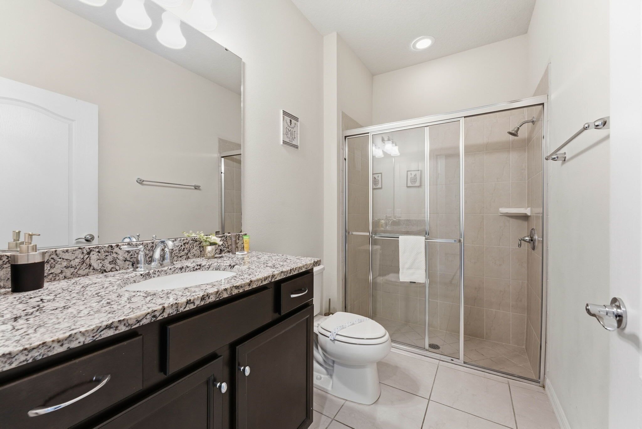 Un bagno con doppio lavabo, un WC e una cabina doccia.
