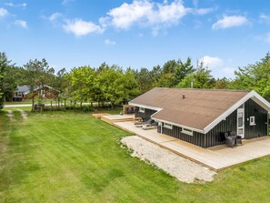 A modern house with a large deck, a separate garage, and a well-maintained lawn. - "Josef" - 1.2km from the sea by Interhome (Løkken)