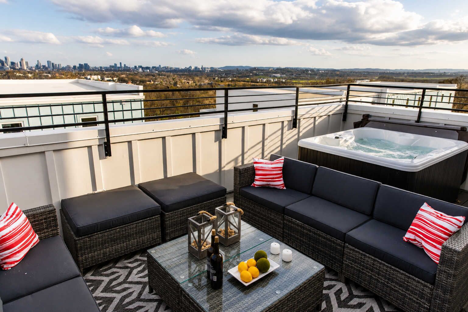 Terraza en la azotea con hidromasaje, mobiliario de mimbre y vistas a la ciudad.