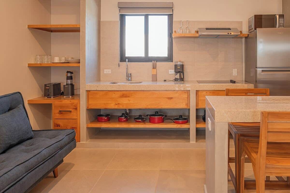 Una cocina compacta con horno integrado, cafetera y microondas.