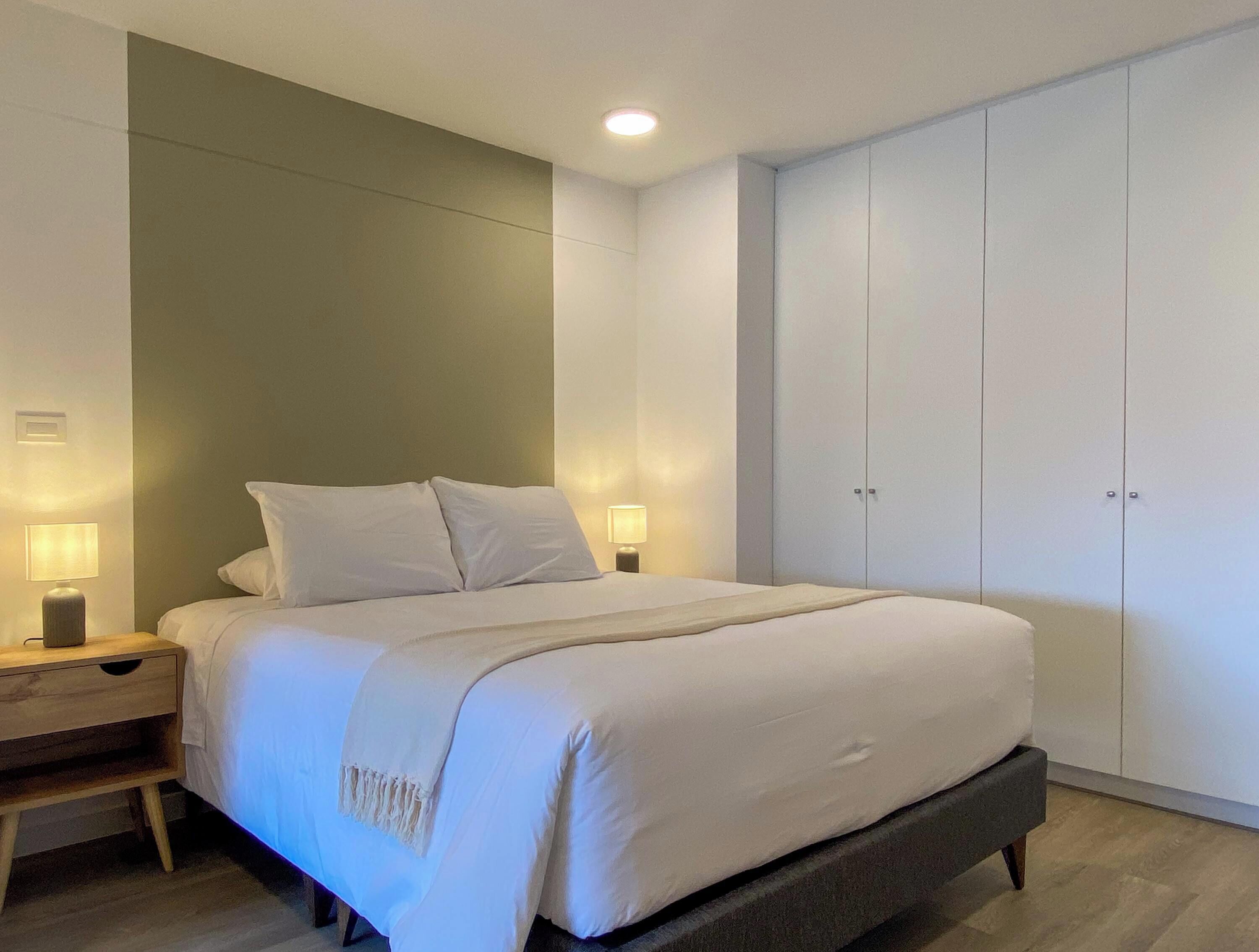 Una camera da letto con un letto, comodini e un armadio.