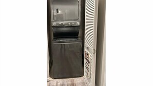 A compact kitchen with a built-in oven and microwave, a small refrigerator, and a white door with a window. - Cozy Apartment in Superb Fort Washington MD-Private Keyless Entry. (Fort Washington)