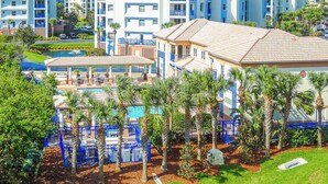 A hotel with a pool area, palm trees, and a view of other buildings. - Oceanwalk Getaway w/Heated Pool + Rocket Views (New Smyrna Beach)