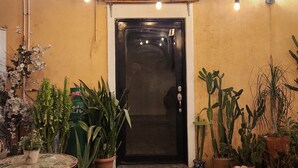 An entrance with a dark door, potted plants, and string lights. - Cozy loft # 1 just 5 minutes from the Malecon of La Paz by car. Pet Friendly! (La Paz)