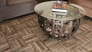 A living room with a round mirror, two hanging pendant lights, a glass coffee table with books, and a herringbone-patterned floor. - Cozy loft # 1 just 5 minutes from the Malecon of La Paz by car. Pet Friendly! (La Paz)
