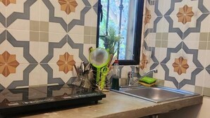 Eine Küche mit gemusterten Fliesen, einem Fenster und einem Spülbecken.
