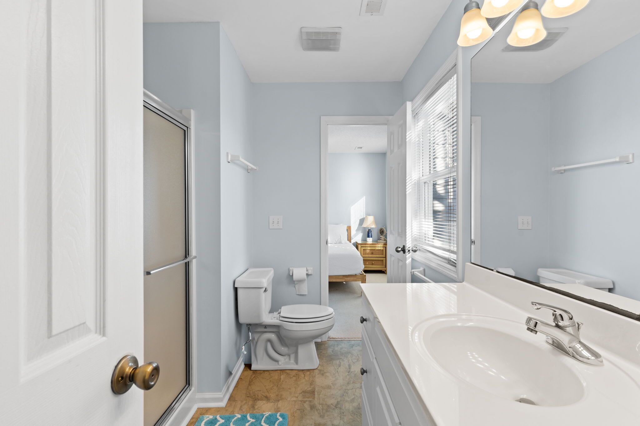 A bathroom with a white sink, a toilet, and a shower area.