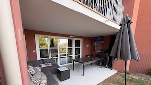 Un patio con un sofá, una mesa y una sombrilla.