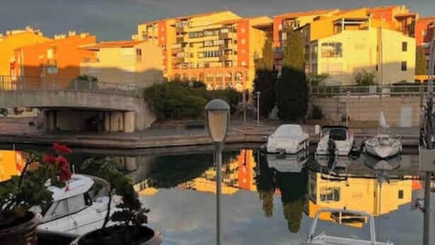 Blick auf das Wasser mit Gebäuden, einer Brücke und Booten.