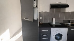 Eine moderne Küche mit integriertem Waschmaschine, einer Mikrowelle und einem Herd.