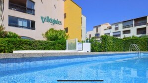 Ein Schwimmbecken mit einem Gebäude im Hintergrund, auf dem 'Villegas' steht.