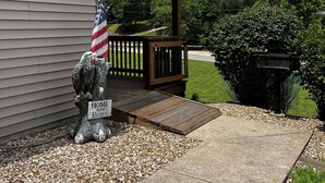 A house with a porch, a flag, and a 'Home of the Brave' sign. - Stay in cozy cabin 5 off of Lake of the Ozarks in beautiful Sunrise Beach, MO (Sunrise Beach)