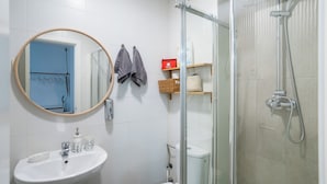 Een badkamer met een wastafel, spiegel en douche.